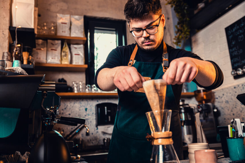 Barista preparing filter coffee in a modern coffee shop.
