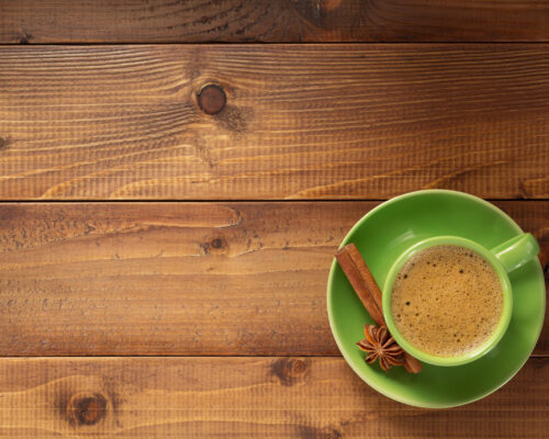 cup of coffee on wooden background, top view