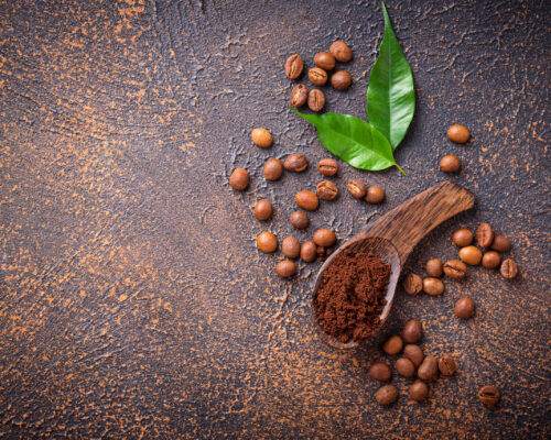 Roasted beans and ground coffee on rusty background. Top view